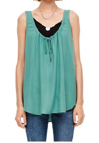 Una blusa sin mangas de color azul verdoso con un escote fruncido y detalle de cordón, hecha de una tela ligera, combinada con una camiseta interior negra.