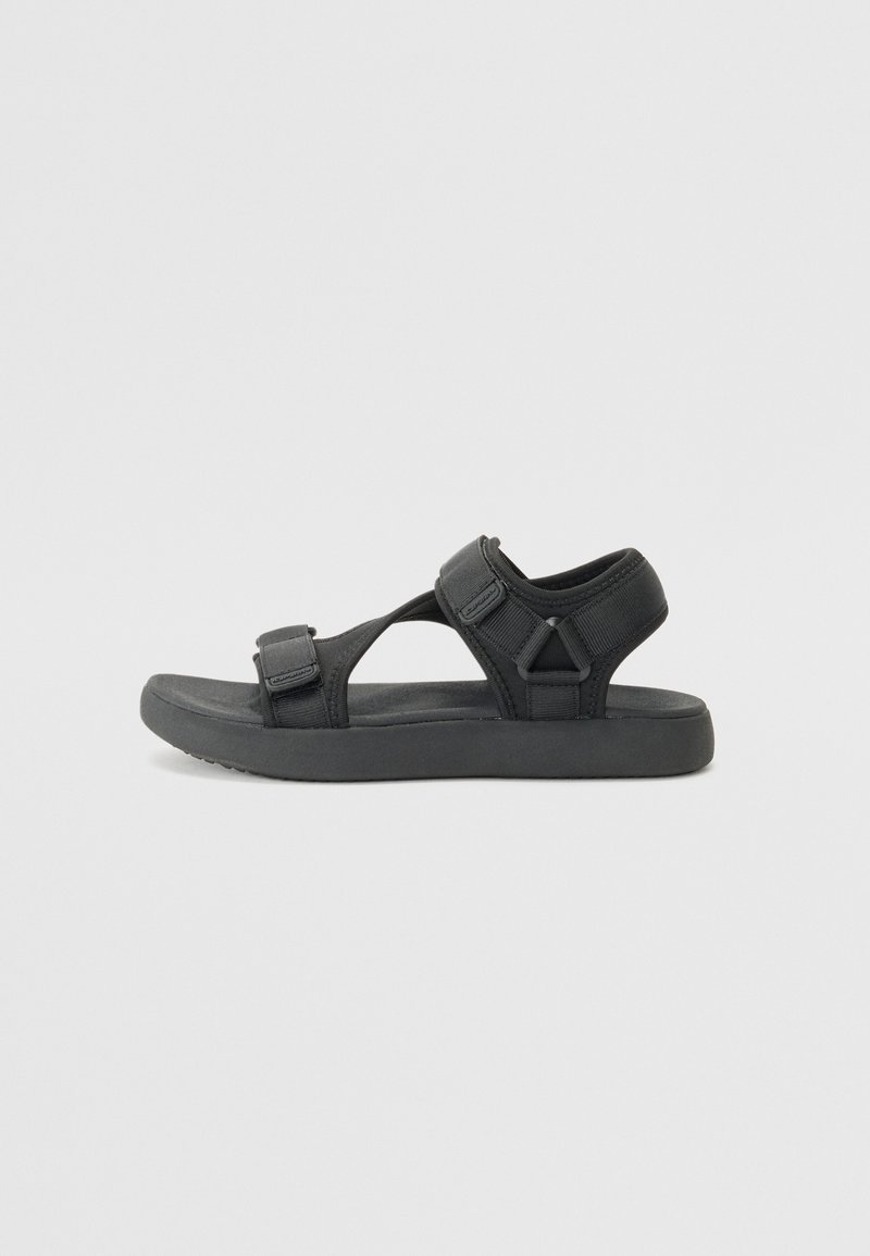 Black sandal featuring a soft, textured upper with adjustable straps and a lightweight sole, designed for comfort and easy wear.