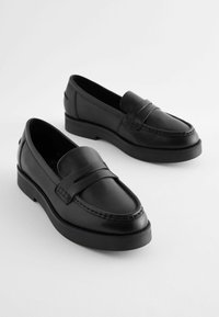Černé kožené loafers s nízkým podpatkem, s páskem přes nárt, švy a hladkým povrchem.