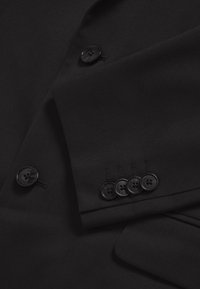Black suit jacket featuring smooth fabric, a notched lapel, one large and four small buttons, with detailed stitching on the cuff.