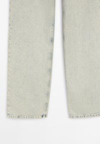 Světle modré džíny rovného střihu vyrobené z denimové látky, s jemnou texturou a mírným blednutím podél látky, se viditelným švem.