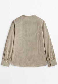 Chemise en velours côtelé beige avec des rayures verticales, manches longues, poignets boutonnés et col rond. Design simple avec une surface texturée.