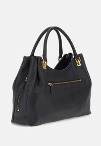 Musta tekstiilipintainen nahkalaukku, jossa on kaksi kantokahvaa, kultaiset vetoketjupussit edessä ja sivulla sekä kultaiset metalliosat.