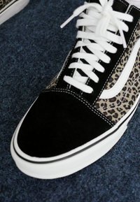 Black and leopard print high-top sneaker with white laces, suede and canvas materials, rubber sole, and contrasting white side stripe.