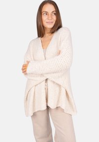 Beige Strick-Cardigan mit offenem Vorderteil. Verfügt über einen lässigen Schnitt mit strukturierter Stoffqualität und hängenden Schultern. Nahtloses Design mit fließendem Saum.