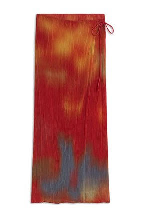 Falda larga plisada con patrón tie-dye en rojo, naranja, amarillo y azul, con un lazo lateral en la cintura.