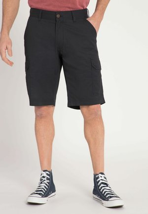 Sorte cargo shorts med to sidelommer, knaplukning og lige pasform, parret med høje navy sneakers og en rød skjorte.