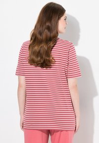 Camiseta de algodón a rayas en coral y blanco, de manga corta, corte relajado, con un escote redondeado y combinada con pantalones a juego.