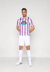 Bela nogometna oprema z vijoličastimi navpičnimi črtami. Kappa logo na rokavih, sponzorstvo Estrella Galicia na sprednji strani. Bele kratke hlače in nogavice.