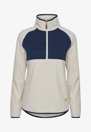 Fleece pullover featuring a cream body, navy quilted yoke, half-zip closure, and accent stitching along the hem and collar.