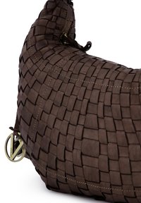 Plecioná kožená taška tmavě hnědé barvy. Má zaoblený tvar, viditelné švy a kovové prvky. Texturovaný povrch s tkaným vzorem.