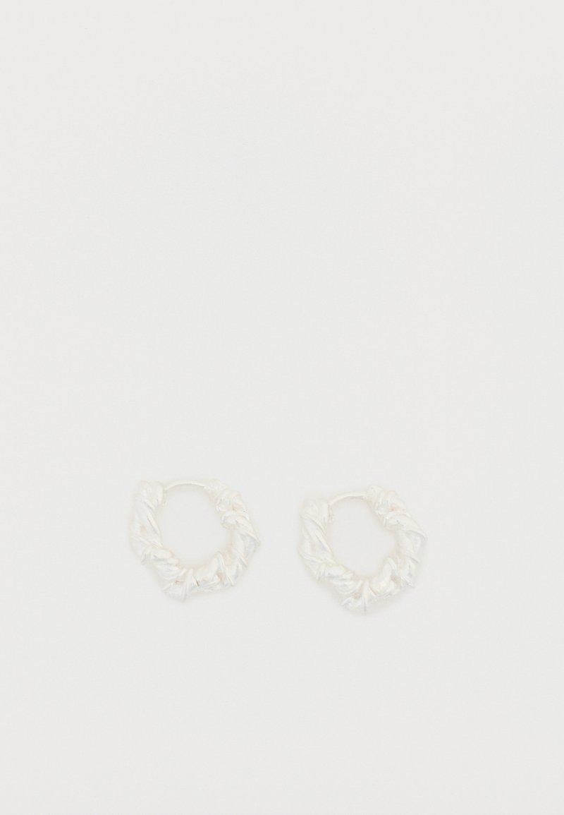 Cercei rotunzi albi cu o textură șifonată. Realizați din material metalic, având un design răsucit și un finisaj neted.