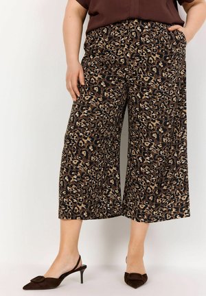 Pantaloni a gamba larga con stampa leopardata marrone, dalla vestibilità ampia, realizzati in un tessuto morbido e dotati di una vita elastica, abbinati a scarpe con tacco marrone scuro.