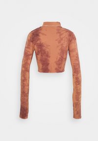 Långärmad kort t-shirt i bränd orange med ett tie-dye-mönster. Mjuk tyg med hög hals och figurnära design, med kontrasterande detaljer.