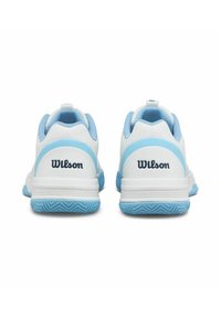 Zapatillas deportivas blancas con acentos azules, que cuentan con una suela de goma texturizada, un cuello acolchado y la marca "Wilson" en el talón.