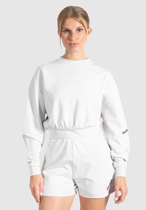 Witte sweatshirt met een ronde halslijn en elastische taille, gecombineerd met bijpassende shorts. Heeft lange mouwen en het merklogo op de mouw.