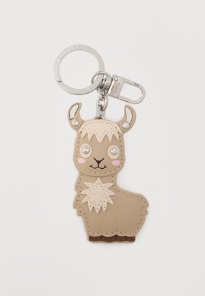 Μπρελόκ με γοητευτικό απαλό υλικό σε σχήμα λάμας μπεζ χρώματος, με ραμμένες λεπτομέρειες, ροζ μάγουλα, μάτια από κουμπιά και μεταλλικό κρίκο και κλιπ προσαρτημένα.