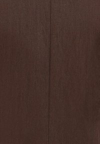 Close-up of brown fabric with diagonal weave texture and central vertical seam stitching.