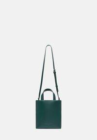 Kwadratowa torebka ze skóry w ciemnozielonym kolorze o gładkiej fakturze, z dwoma krótkimi uchwytami oraz regulowanym długim paskiem, umożliwiającym różne sposoby noszenia.