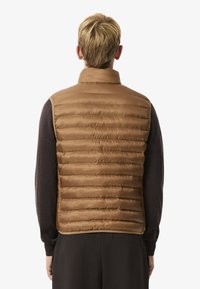 Bruine puffer vest met horizontale stiksels, hoge kraag en mouwloos ontwerp. Glad textuur en eenvoudige stijl voor laagjes. 