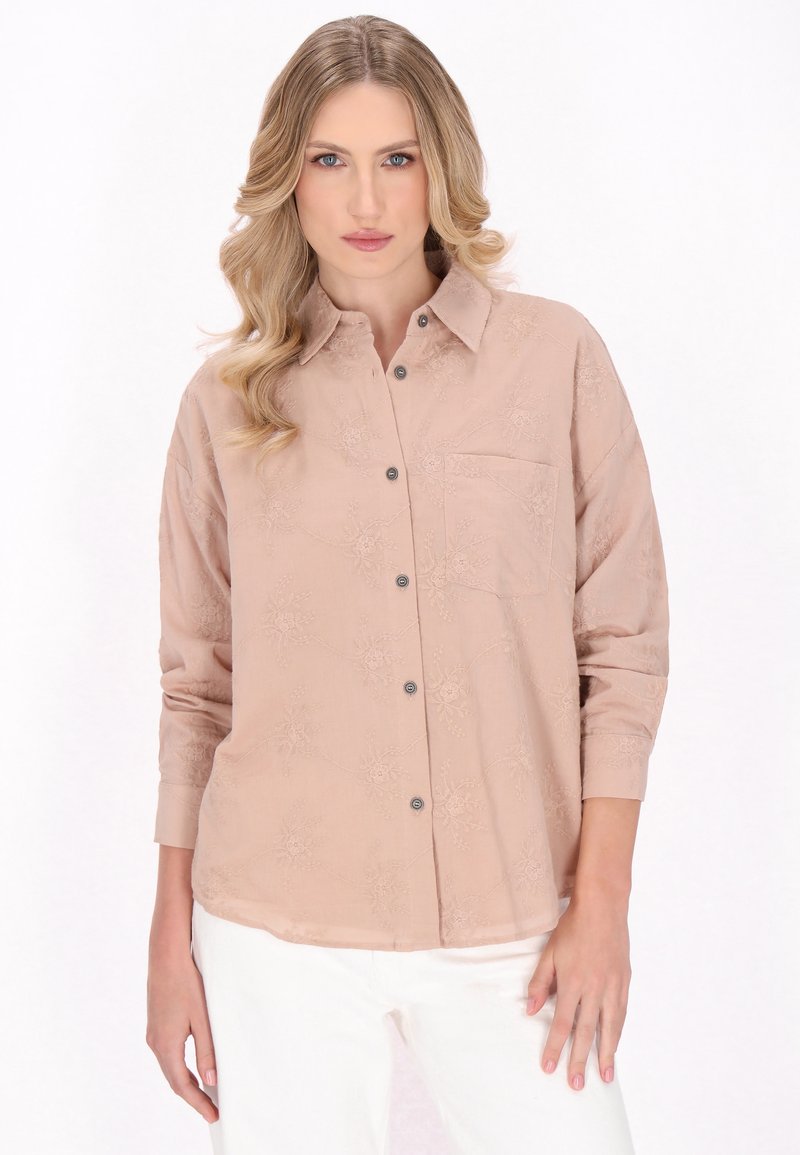 Camicia button-up rosa chiaro con motivi floreali ricamati, una singola tasca sul petto e maniche arrotolate. Realizzata in un tessuto morbido e testurizzato.