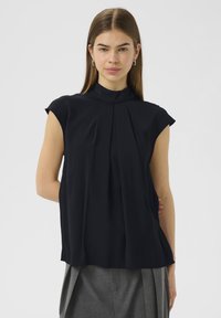 Blusa nera senza maniche con colletto alto, caratterizzata da pieghe verticali e un tessuto morbido e fluido. Design semplice senza motivi visibili.