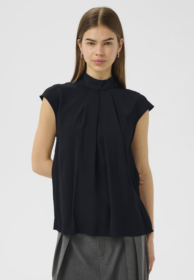 Blusa nera senza maniche con colletto alto, caratterizzata da pieghe verticali e un tessuto morbido e fluido. Design semplice senza motivi visibili.