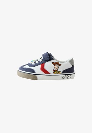 Hvid sneaker med marineblå detaljer. Har en rød stribe, velcrolukning og et billede af Woody fra Toy Story på siden. Gummisål.