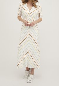 Maxiklänning med korta ärmar, med en knäppt framdel och en krämfärgad bakgrund. Den har flerfärgade diagonala ränder och en figurnära midja.