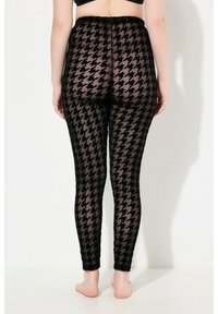 Leggings neri trasparenti con motivo a scozzese, design a vita alta e cintura elastica. Finitura testurizzata visibile attraverso il tessuto.