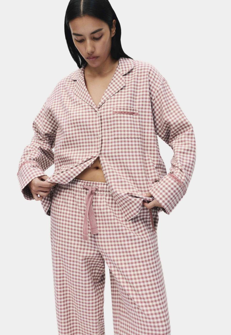 Ensemble de pyjama à carreaux roses et blancs en tissu doux ; comprend une chemise à manches longues à boutons et un pantalon à taille élastique avec cordon.