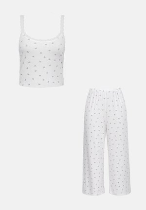 Weißes Pyjama-Set mit dünnen Trägern und Spitzenbesatz am Oberteil, mit kleinen grauen Schmetterlingsmotiven auf Oberteil und weit geschnittenen Hosen.
