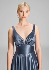 Abito in satin blu scuro con profondo scollo a V, corpetto plissettato e una vestibilità aderente con gonna svasata. Tessuto liscio con una leggera lucentezza.