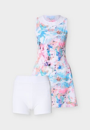 Vestido deportivo sin mangas con estampado abstracto multicolor, combinado con pantalones cortos ajustados blancos lisos sobre un fondo claro.