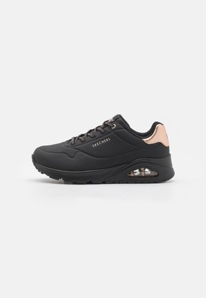 Czarny sneaker Skechers z różowo-złotym detalem na pięcie, amortyzowaną powietrzem podeszwą, sznurowanym przodem i logo Skechers po boku.