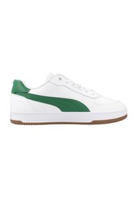 Zapatilla deportiva blanca de cuero con acentos verdes, que cuenta con un collar acolchado, punta redonda y una suela de goma texturizada.