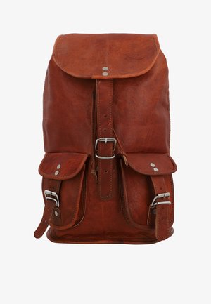 Sac à dos en cuir marron avec un rabat supérieur, une sangle centrale à boucle, et deux poches avant sécurisées par des sangles à boucle.