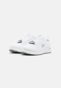 Baskets de sport blanches en mesh avec une tige texturée, fermeture à lacets, semelle flexible et détail de logo sur le côté. Design minimaliste.