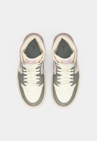 Hall gray, valge ja roosa kõrge suusajalatsite paar, mille valged paelad on vaadatavad ülevalt, ühtlasel heledal taustal.