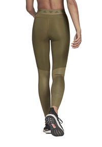 Olijfgroene high-waisted legging met een gladde textuur, voorzien van een logoband in de taille en contrasterende paneeldetails bij de kuiten.