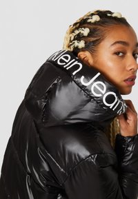 Calvin Klein Jeans SHINY LONG FITTED JACKET - Talvejope - ck black/bright white