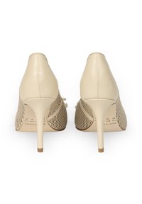 Beżowe szpilki z gładkiej skórzanej cholewki oraz perforowanymi siateczkowymi bokami, z wąskim obcasem i szpiczastym noskiem.
