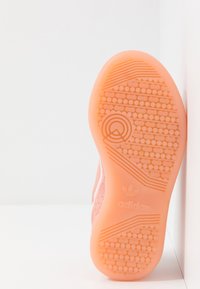 Suola in gomma rosa con motivo testurizzato per una presa ottimale e discreta personalizzazione adidas. Il design presenta una forma arrotondata e bordi morbidi.