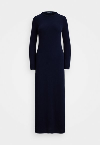 Vestido de malha azul marinho, com mangas longas, gola redonda e silhueta ajustada, que chega aos tornozelos. Textura suave e design minimalista.