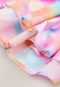 Tela de chiffon multicolor con un degradado de tonos rosa, azul y naranja, bordes suaves enrollados y textura lisa.