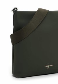 Borsa a tracolla in gomma verde dal design piatto, con tracolla in tessuto, ferrature argentate e un dettaglio logo discreto sul davanti.