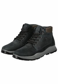Botas de tobillo de cuero negro con suela de goma gris, diseño con cordones, cuello acolchado y detalles de costura en contraste. Superficie texturizada.