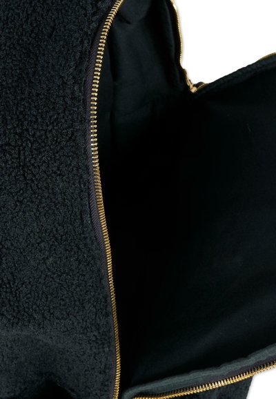 Zaino nero con esterno in pile testurizzato, cerniera dorata e un ampio interno rivestito in tessuto nero.