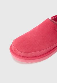 Rosa mockaläder slip-insko med rund tå och gummisula. Har minimal sömnad och en slät, ren design.
