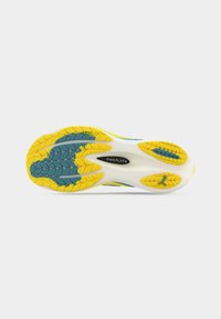 Σόλα παπουτσιού με κίτρινο καουτσούκ με υφασμένη πρόσφυση, μπλε λεπτομέρειες και λευκή βάση. Περιλαμβάνει ορατή εμπορική σήμανση στο κέντρο.